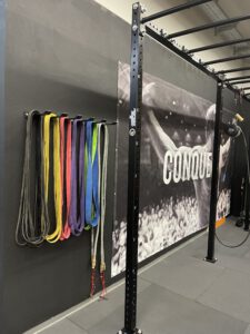Resistance Bänder in verschiedenen Farben hängen an der Wand im Trainingsbereich.