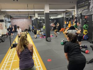 Teilnehmer des Mein CLUB Burghausen trainieren in einer intensiven Hyrox-Einheit mit Sled Pushes und Functional Workouts.