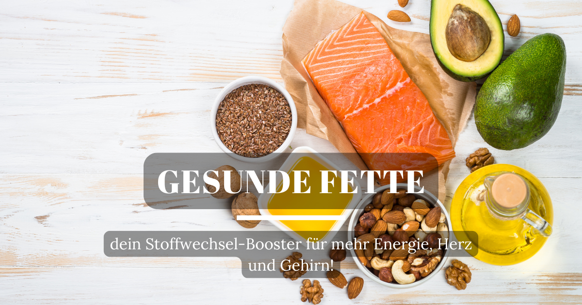 Lebensmittel reich an gesunden Fetten: Avocado, Kokosnuss, Nüsse und Kichererbsen auf einem Tisch angerichtet.